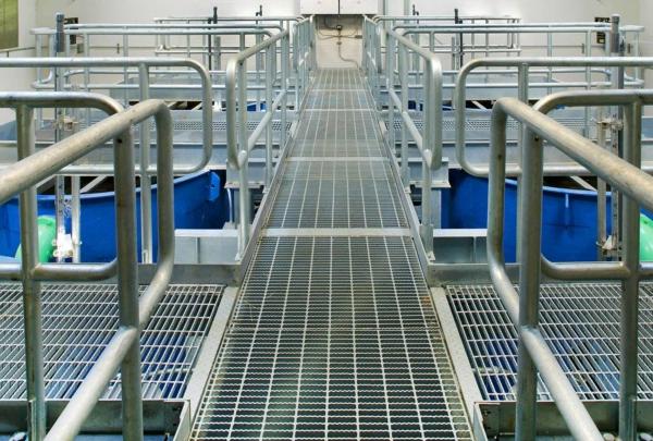 Aluminum grating walkways above six large blue tanks at the Indian Head Wastewater Treatment Plant.